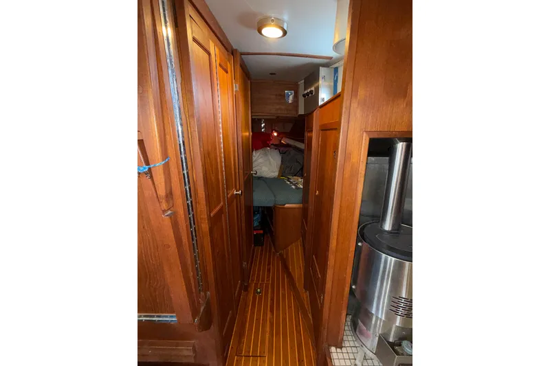 Slide: The Image of Interior of 1983 Valiant Cutter sailboat with wooden cabinetry and cozy sleeping area. - 13