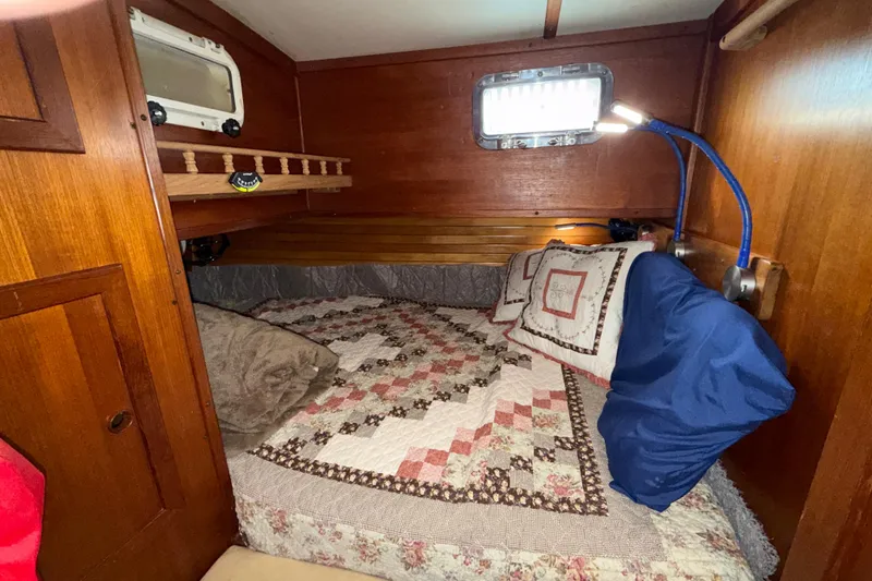 Slide: The Image of Cozy cabin interior of 1983 Valiant Cutter with quilted bedding and wooden accents. - 15