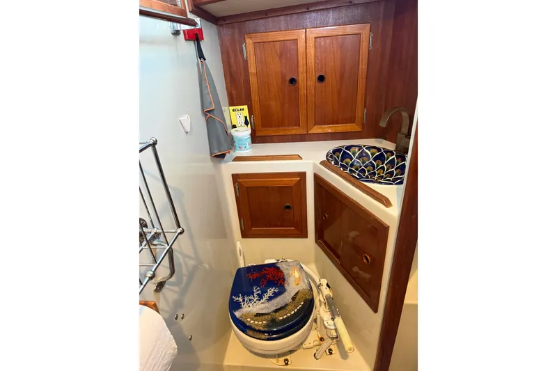 Slide: The Image of 1983 Valiant Cutter boat bathroom with wooden cabinets and decorative sink. - 16