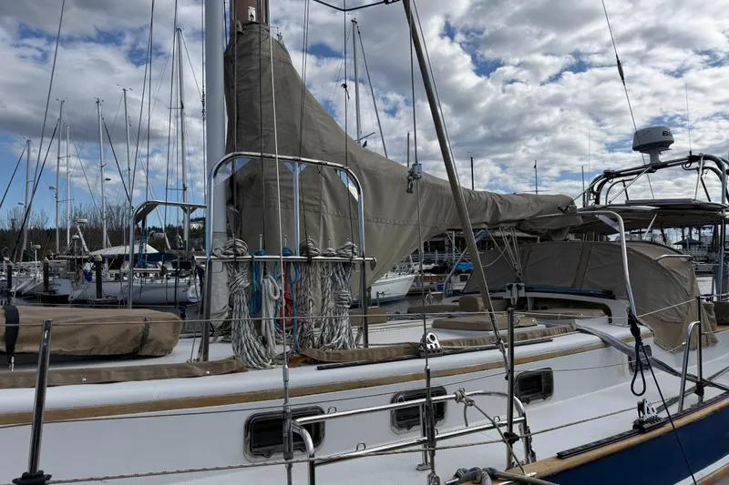 Slide: The Image of 1983 Valiant Cutter sailboat docked at marina under cloudy sky. - 20
