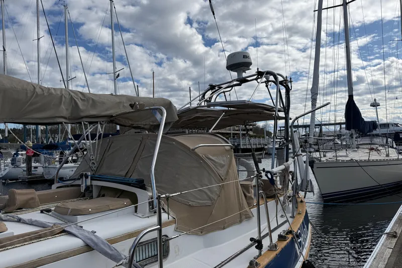 Slide: The Image of 1983 Valiant Cutter sailboat docked at marina under cloudy sky. - 21