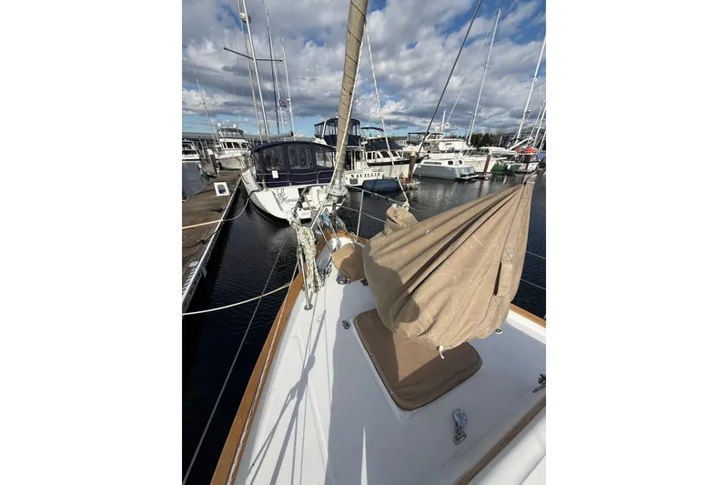 Slide: The Image of 1983 Valiant Cutter sailboat docked at marina under cloudy sky. - 28