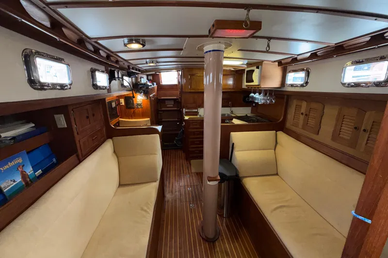 Slide: The Image of Interior of a 1983 Valiant Cutter sailboat with wooden furnishings and cozy seating. - 3