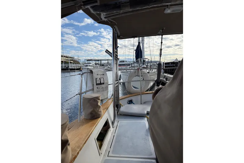 Slide: The Image of 1983 Valiant Cutter sailboat docked at marina, view from cockpit under cloudy sky. - 30