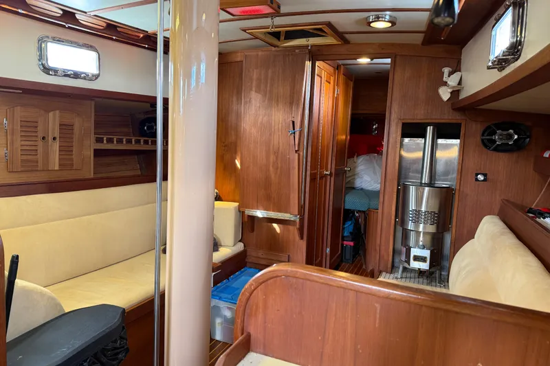 Slide: The Image of Interior of a 1983 Valiant Cutter sailboat with wood paneling and cozy seating. - 6