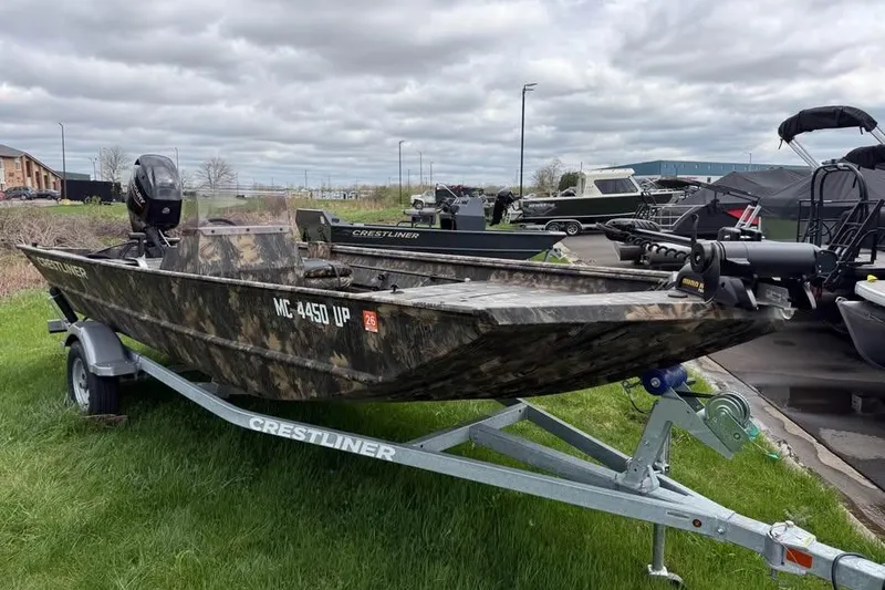 Slide: The Image of 2021 Crestliner 1760 Retriever SC boat on trailer, camo design, parked outdoors. - 4