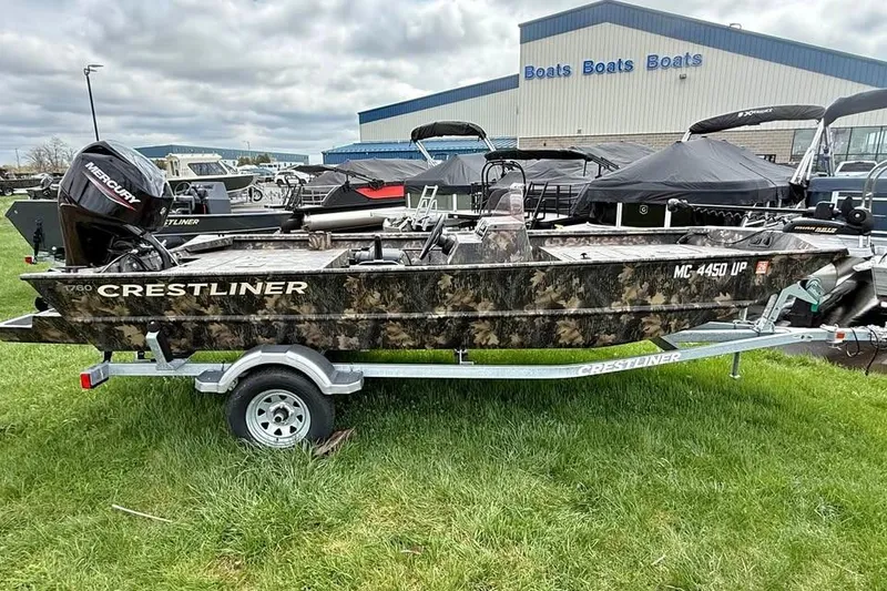 Slide: The Image of 2021 Crestliner 1760 Retriever SC boat on trailer, displayed outdoors near dealership. - 5