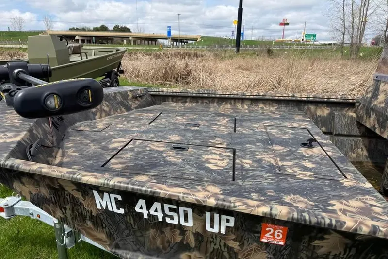 Slide: The Image of 2021 Crestliner 1760 Retriever SC boat with camouflage design, parked on grass. - 6
