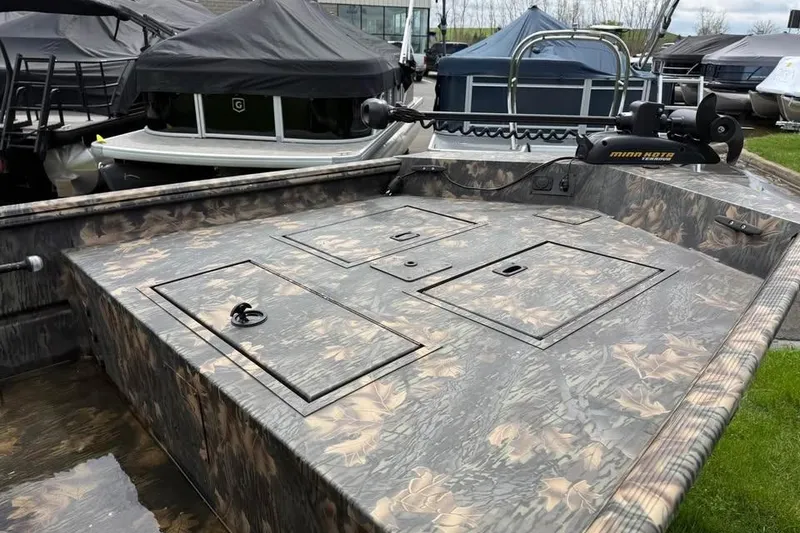 Slide: The Image of 2021 Crestliner 1760 Retriever SC boat with camo design, featuring storage compartments and a trolling motor. - 7