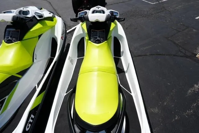 Slide: The Image of 2017 Sea-Doo GTI jet skis in bright yellow and white, parked on asphalt. - 10