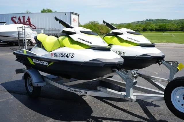 Slide: The Image of 2017 Sea-Doo GTI jet skis on a trailer, parked outdoors on a sunny day. - 2