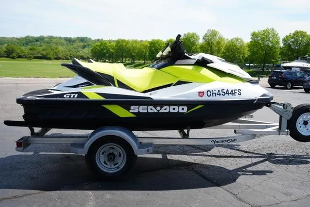 Slide: The Image of 2017 Sea-Doo GTI jet ski on trailer, parked outdoors with green landscape background. - 3