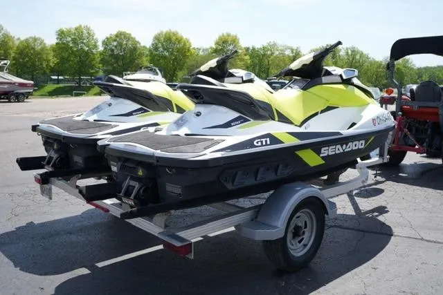 Slide: The Image of Two 2017 Sea-Doo GTI jet skis on a trailer in a sunny outdoor setting. - 4
