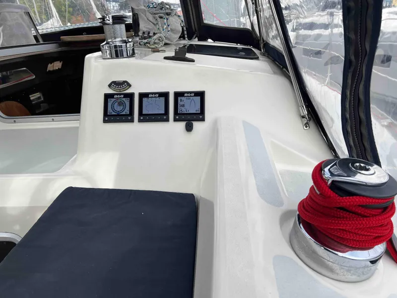 Slide: The Image of Interior of a 1990 Hunter 37.5 sailboat cockpit with navigation instruments and red rope. - 13