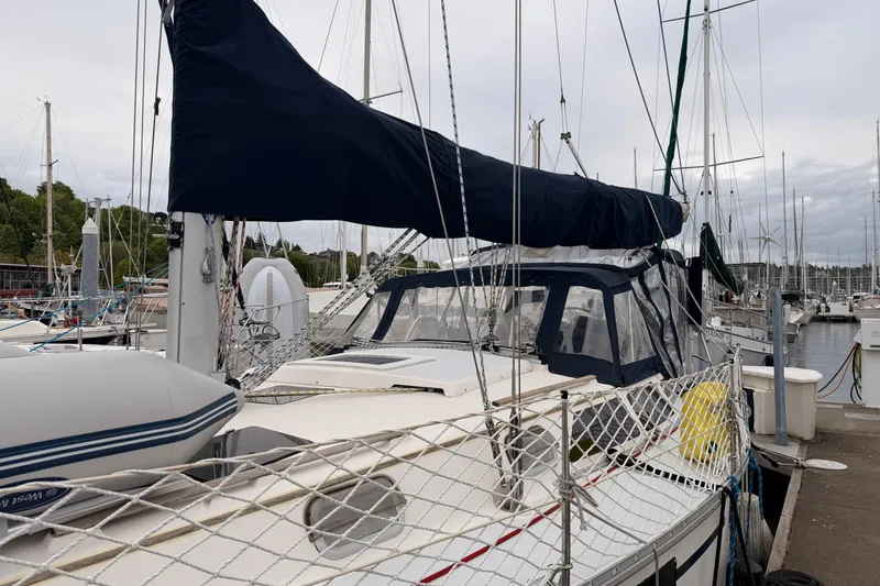 Slide: The Image of 1990 Hunter 37.5 sailboat docked at marina, featuring covered cockpit and rigging. - 23