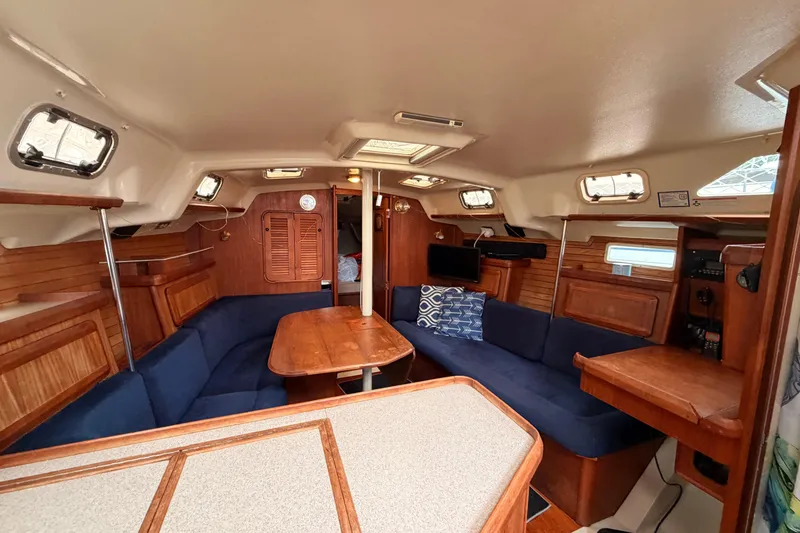 Slide: The Image of Interior of a 1990 Hunter 37.5 sailboat with wooden furnishings and blue seating. - 3