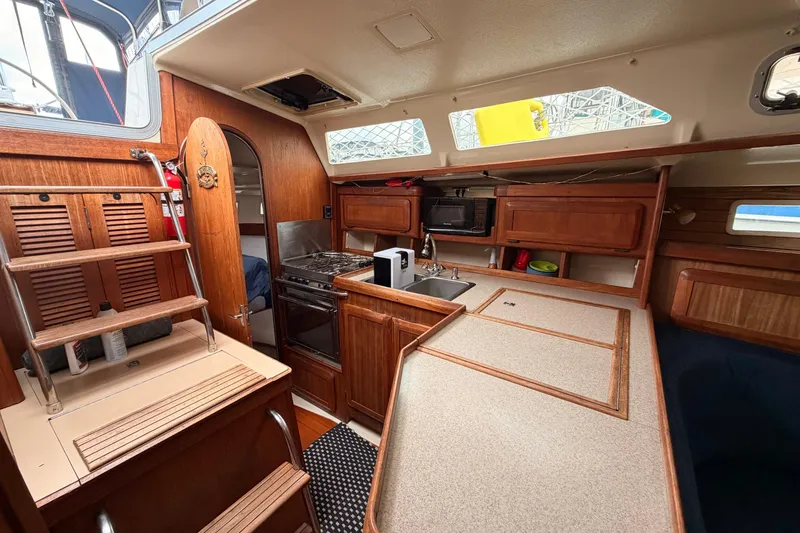 Slide: The Image of Interior of a 1990 Hunter 37.5 sailboat featuring a well-equipped kitchen area. - 6