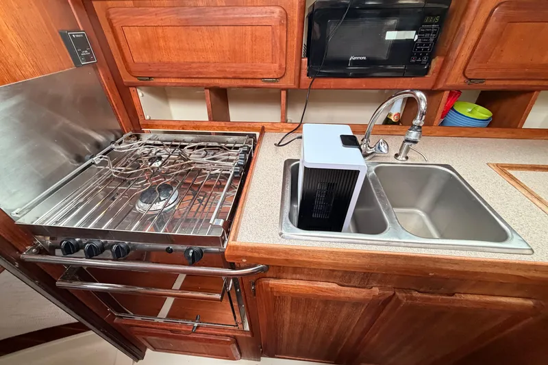 Slide: The Image of Compact kitchen in a 1990 Hunter 37.5 sailboat with stove, sink, and microwave. - 7