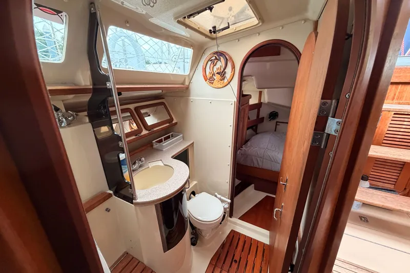 Slide: The Image of Interior of a 1990 Hunter 37.5 sailboat featuring a compact bathroom and cozy cabin. - 8