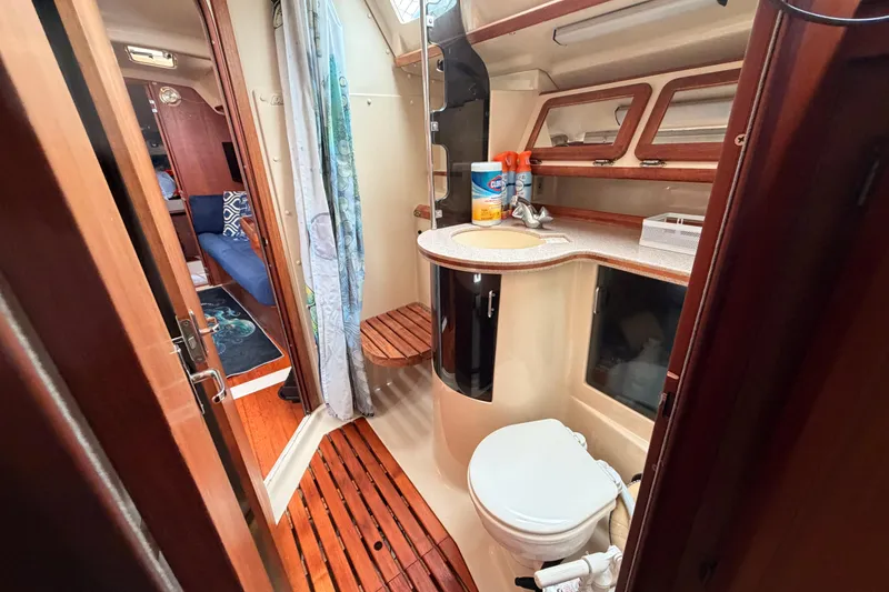Slide: The Image of 1990 Hunter 37.5 yacht bathroom with wooden flooring, sink, and toilet. - 9