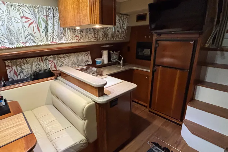 Slide: The Image of 2004 Cruisers Yachts 405 Express Motoryacht interior with kitchen and seating area. - 23
