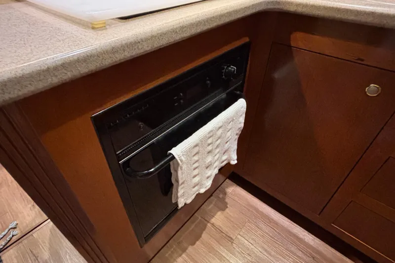 Slide: The Image of 2004 Cruisers Yachts 405 Express Motoryacht kitchen with built-in oven and wooden cabinetry. - 34
