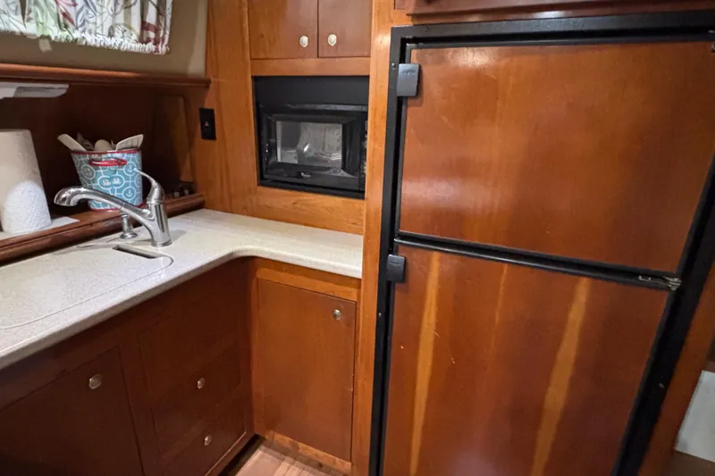 Slide: The Image of 2004 Cruisers Yachts 405 Express Motoryacht kitchen with wood cabinetry and modern appliances. - 35