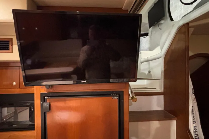 Slide: The Image of Interior of 2004 Cruisers Yachts 405 Express Motoryacht with TV and wooden cabinetry. - 36