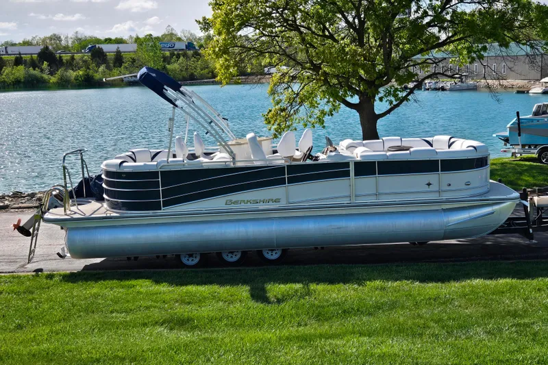 The Image of 2018 Berkshire 25E STS Entertainment pontoon boat by a scenic lakeside. - 0