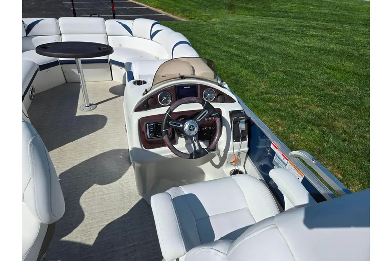 Slide: The Image of 2018 Berkshire 25E STS Entertainment boat interior with steering wheel and seating area. - 16