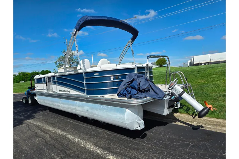 Slide: The Image of 2018 Berkshire 25E STS Entertainment pontoon boat on trailer, blue sky background. - 4