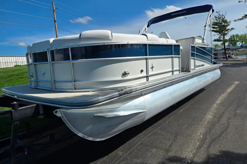 Slide: The Image of 2018 Berkshire 25E STS Entertainment pontoon boat on trailer, under clear blue sky. - 6
