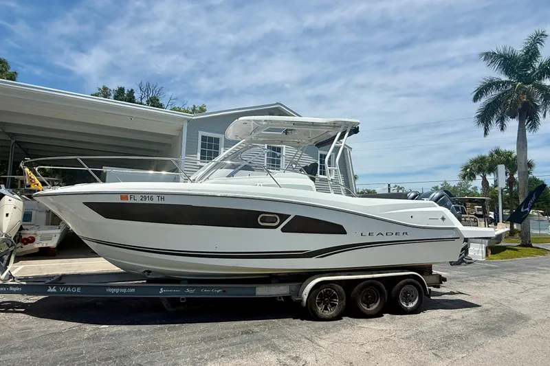 The Image of 2022 Jeanneau Leader 9.0 WA boat on trailer, parked outdoors under a clear sky. - 0