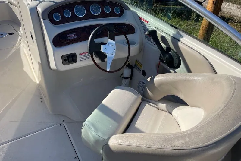 Slide: The Image of 2004 Sea Ray 240 Sundeck boat cockpit with steering wheel and control panel. - 10