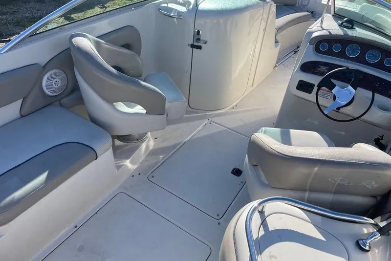Slide: The Image of 2004 Sea Ray 240 Sundeck interior with seating and steering wheel, showcasing spacious design. - 11
