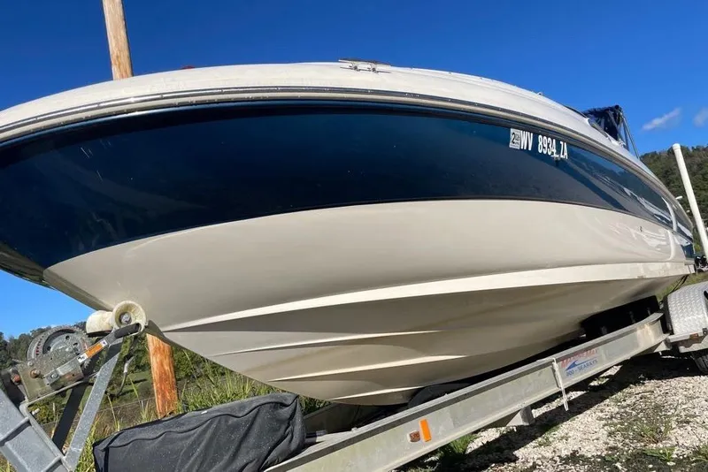 Slide: The Image of 2004 Sea Ray 240 Sundeck boat on trailer under clear blue sky. - 14