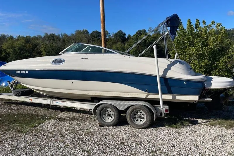 Slide: The Image of 2004 Sea Ray 240 Sundeck boat on trailer, parked outdoors on gravel. - 9