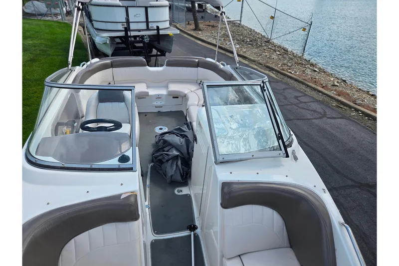 Slide: The Image of 2007 Yamaha Boats SX230 HO interior view, featuring seating and steering wheel near a lakeside. - 19