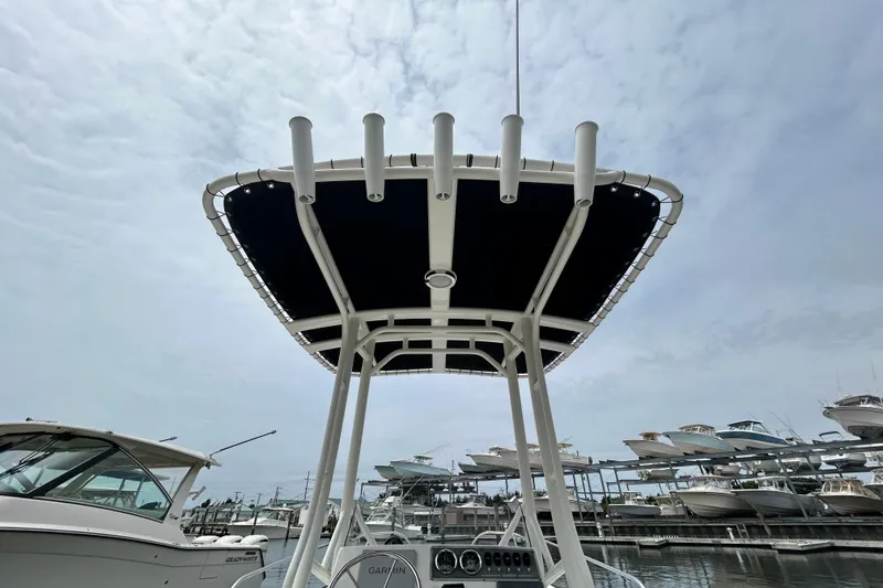 Slide: The Image of Boston Whaler 190 Montauk 2022 boat with T-top, docked at marina under cloudy sky. - 13