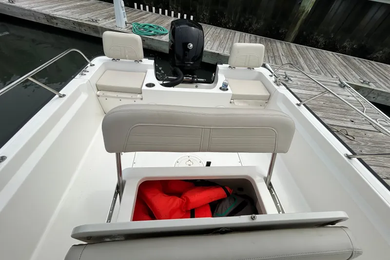 Slide: The Image of 2022 Boston Whaler 190 Montauk boat interior with storage compartment and life jackets. - 16