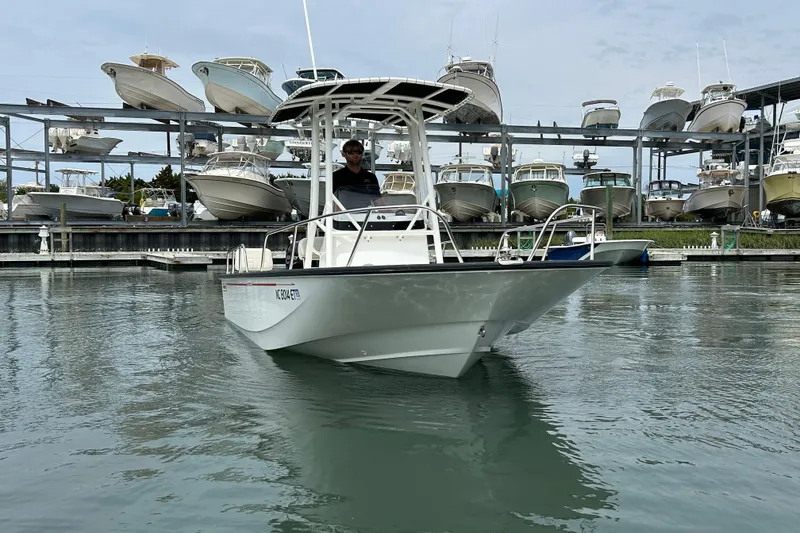 Slide: The Image of 2022 Boston Whaler 190 Montauk boat docked in marina with stacked boats in background. - 2