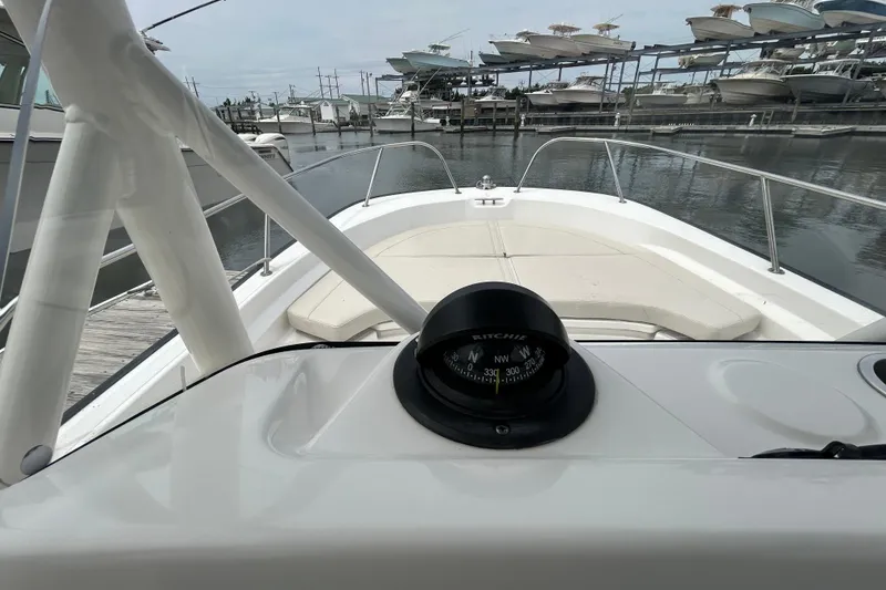 Slide: The Image of 2022 Boston Whaler 190 Montauk boat interior with compass, docked at marina. - 22