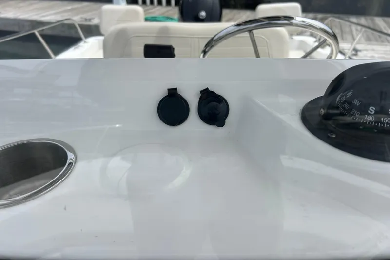 Slide: The Image of Dashboard of 2022 Boston Whaler 190 Montauk with compass and cup holder. - 23