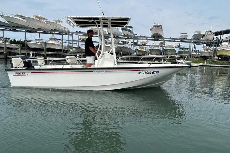 Slide: The Image of 2022 Boston Whaler 190 Montauk boat on water, with marina background. - 4