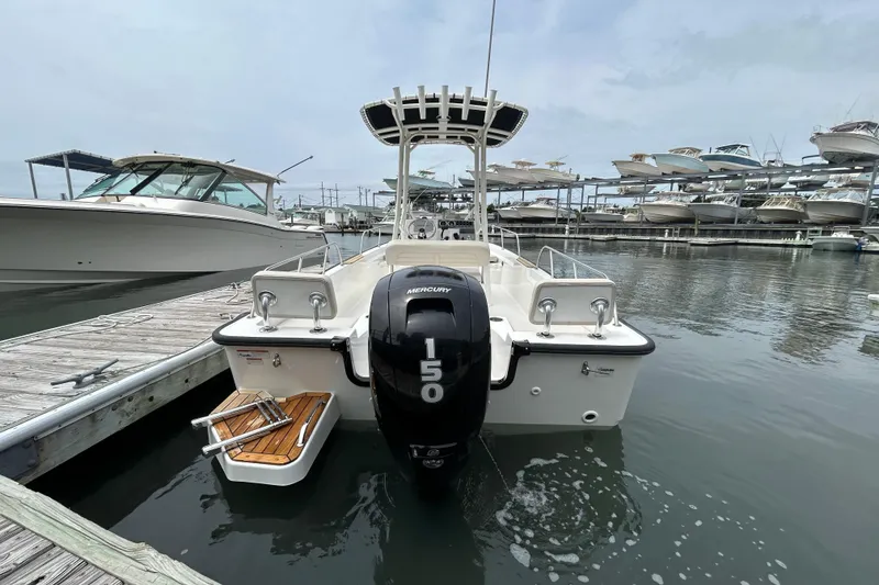Slide: The Image of 2022 Boston Whaler 190 Montauk boat docked, featuring a Mercury 150 engine, in a marina setting. - 6