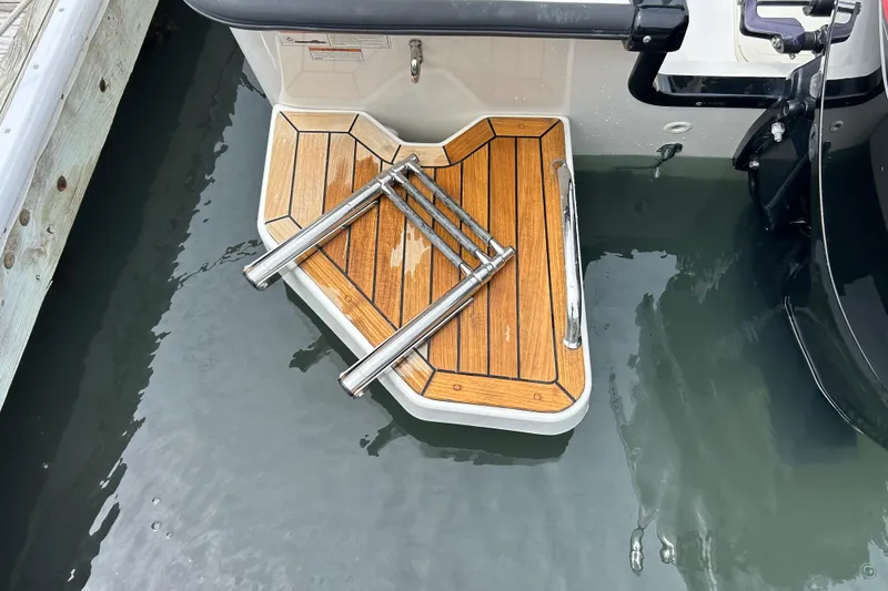 Slide: The Image of Boston Whaler 190 Montauk 2022 swim platform with ladder on calm water. - 7