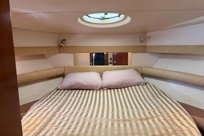 Slide: The Image of Cozy bedroom interior of 2005 Meridian 368 Motoryacht with striped bedding and porthole. - 27
