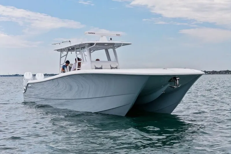 Slide: The Image of 2021 Invincible 46 Catamaran cruising on calm waters under a partly cloudy sky. - 1