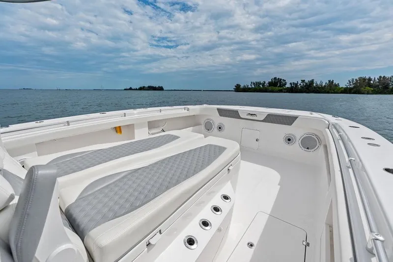 Slide: The Image of Invincible 46 Catamaran 2021, spacious deck with seating, ocean view, clear sky. - 23