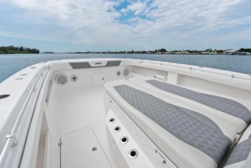 Slide: The Image of Invincible 46 Catamaran 2021, spacious deck with cushioned seating, on calm waters. - 24